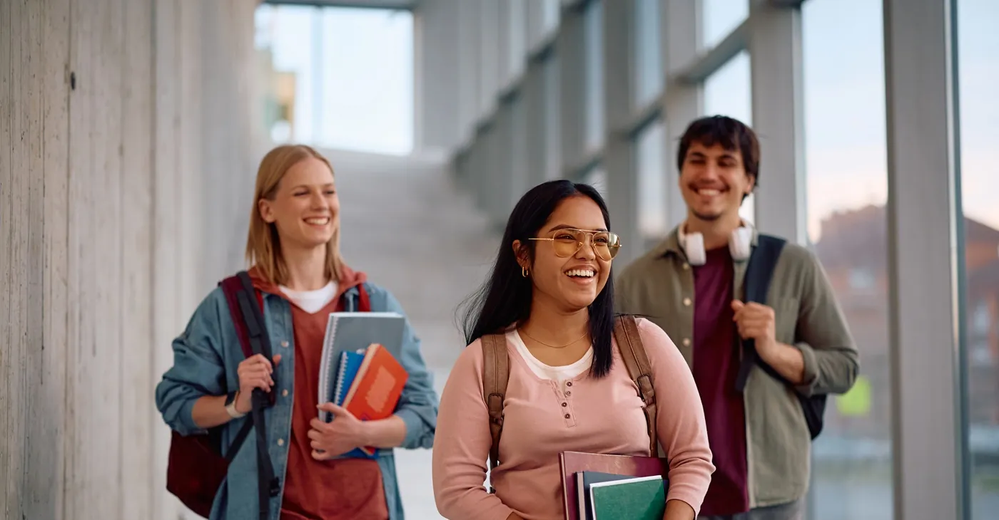 Happy Indian college student and her friends walking through campus.